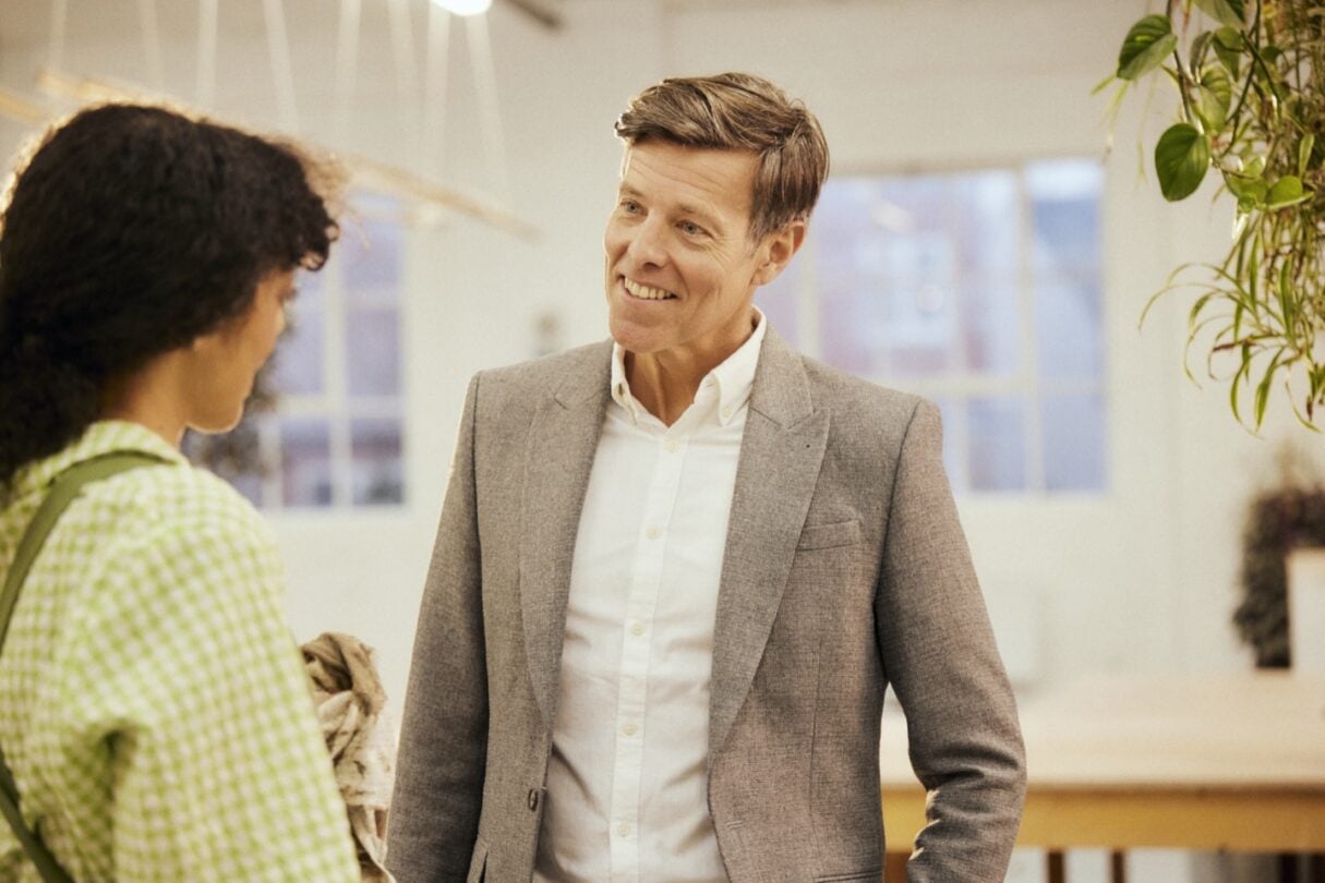 Consultor financeiro a conversar com o cliente num ambiente profissional, oferecendo aconselhamento personalizado.