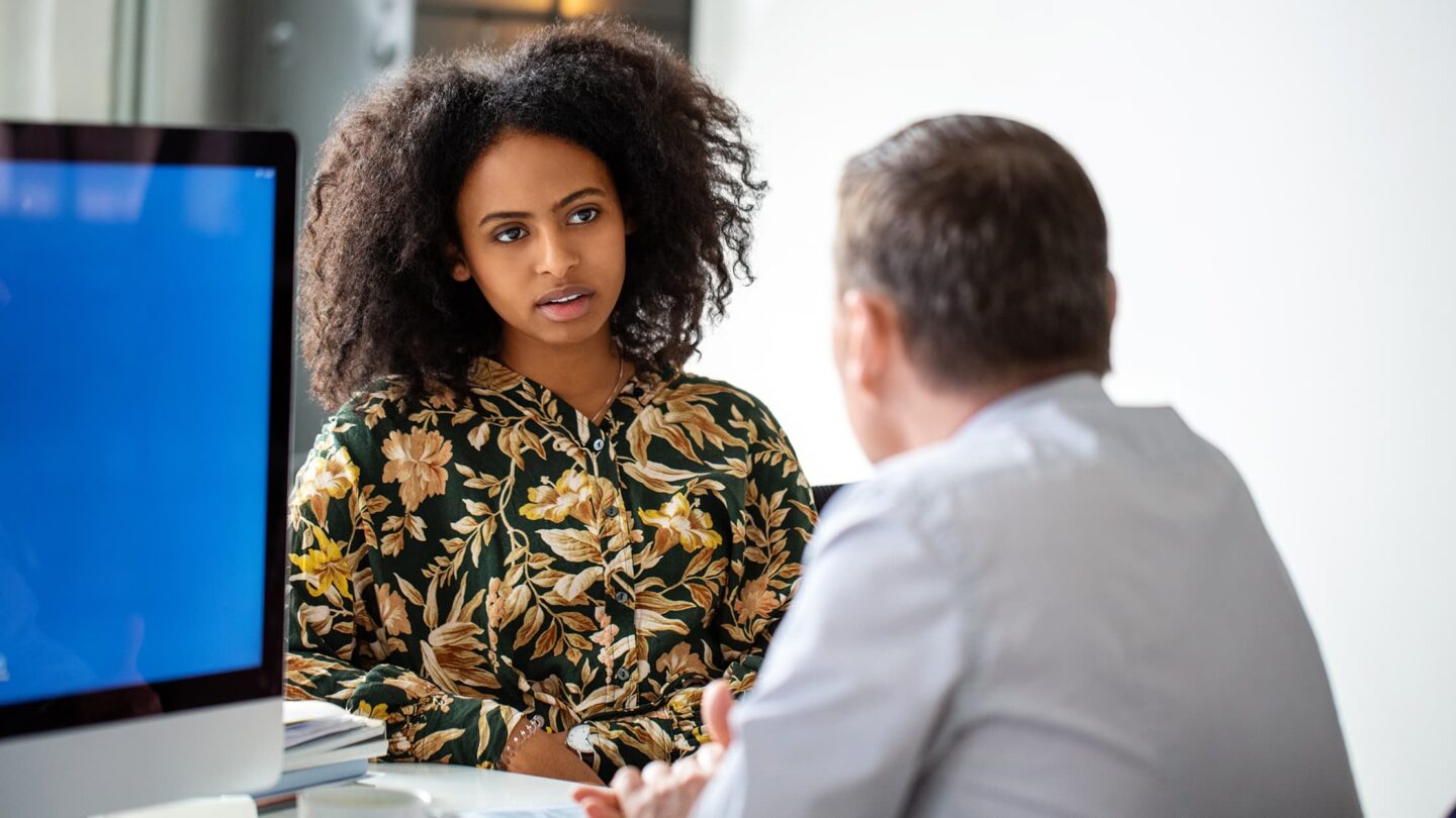 Dois colegas de trabalho a conversar no escritório