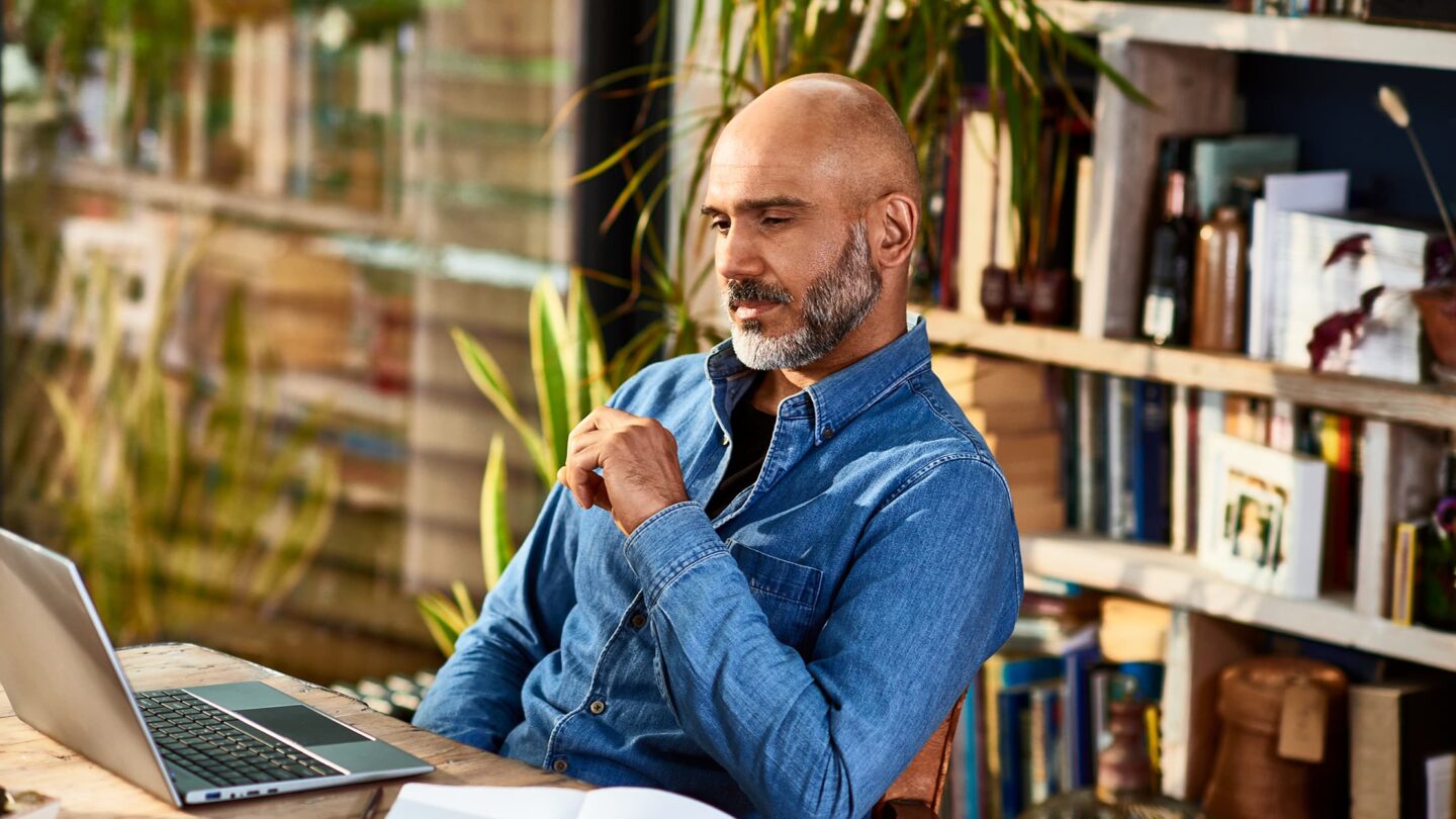 Homem a trabalhar em frente ao seu computador.