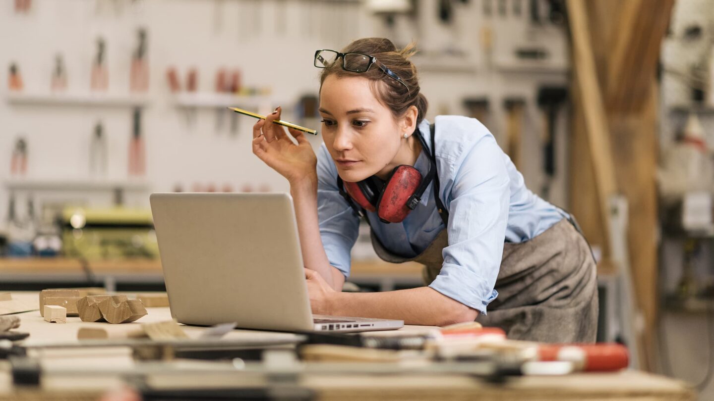 Uma jovem mulher a rever temas no seu computador portátil.