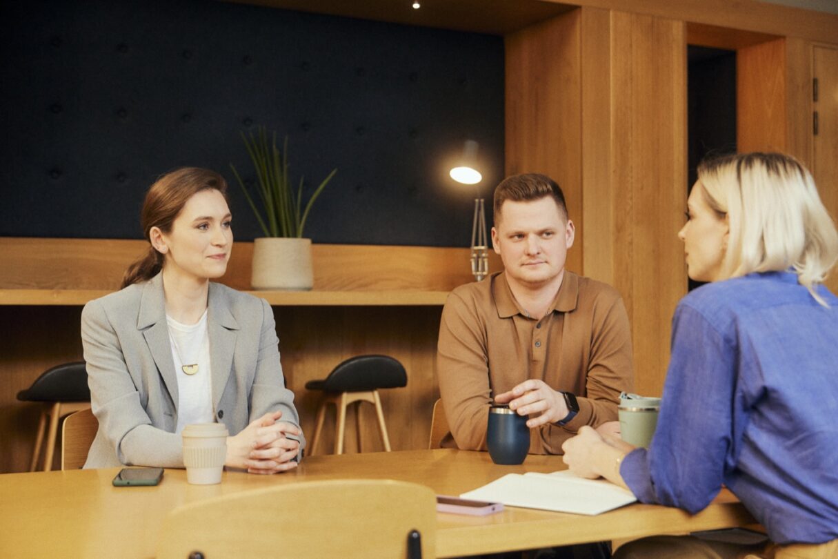 Um grupo de colegas a olhar para um computador, colaborando e discutindo ideias.