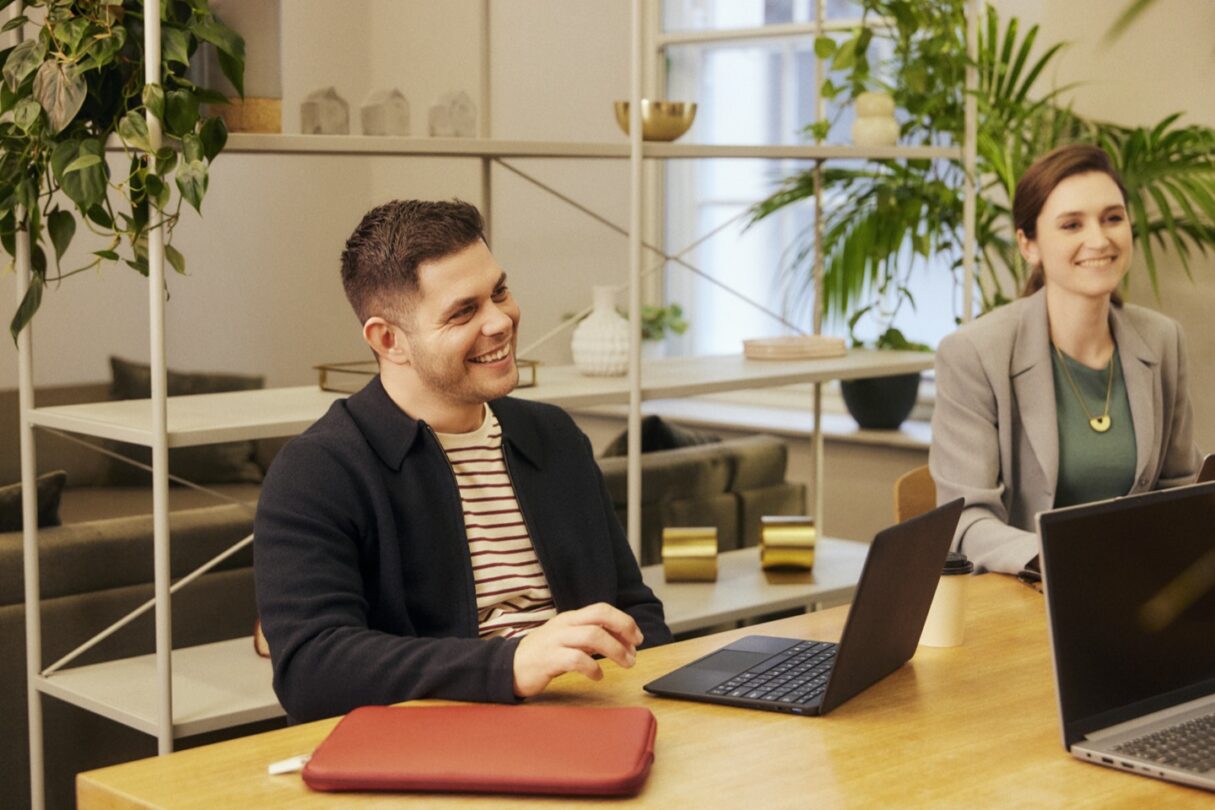 Um grupo de colegas de trabalho reunidos numa sala de reuniões, discutindo e colaborando em torno de uma mesa.
