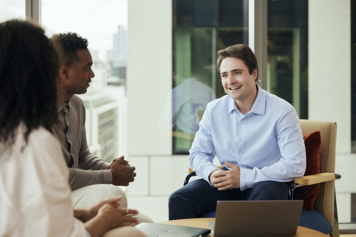 Duas pessoas conversando durante uma reunião.