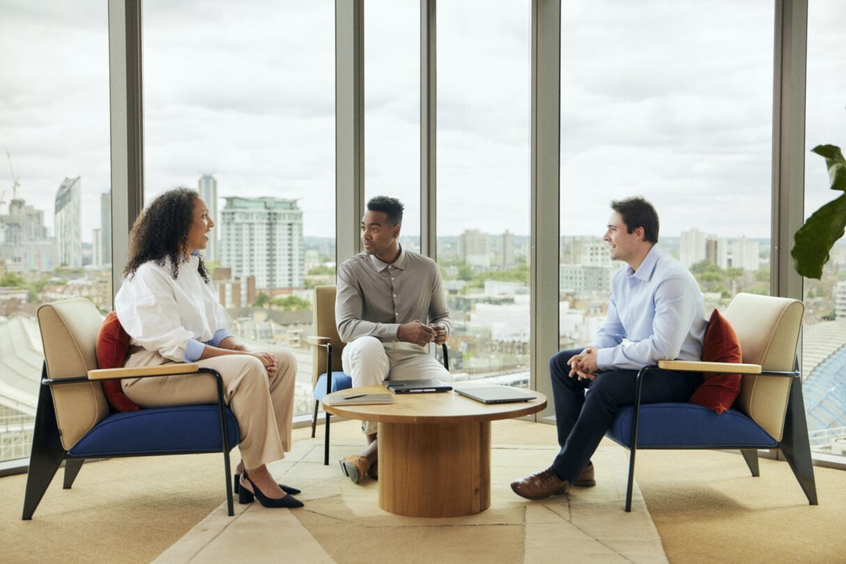 Grupo de trabalhadores em reunião de equipa, discutindo estratégias e colaborando em projetos.