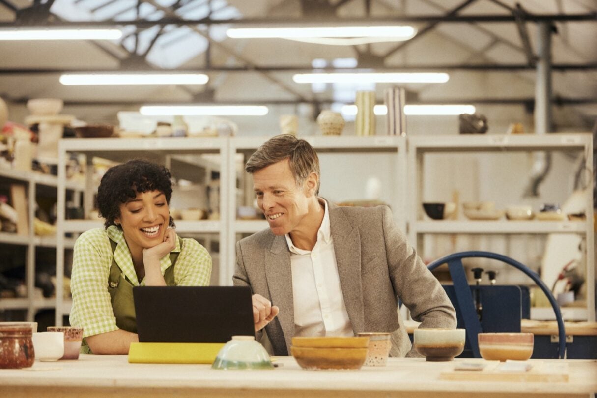 Uma empreendedora conversa com o seu assessor, discutindo estratégias de negócios em um ambiente profissional.